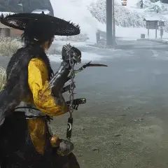Un guerriero con un cappello conico e un mantello di pelliccia si prepara a combattere in un paesaggio innevato, forse in Ghost of Tsushima 2.