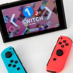 Nintendo Switch con Joy-Con blu e rossi, pronto per le vendite. Schermo mostra "1-2-Switch".