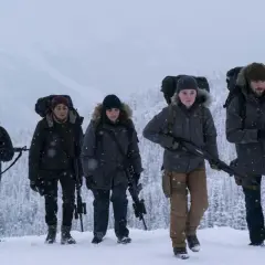 Un gruppo di sopravvissuti armati cammina nella neve, un'immagine che evoca la tensione di "the last of us 3".