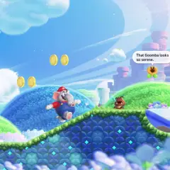 Mario, trasformato in elefante, salta in un mondo colorato di Super Mario Bros. Wonder. Un Goomba osserva una fontana serena.