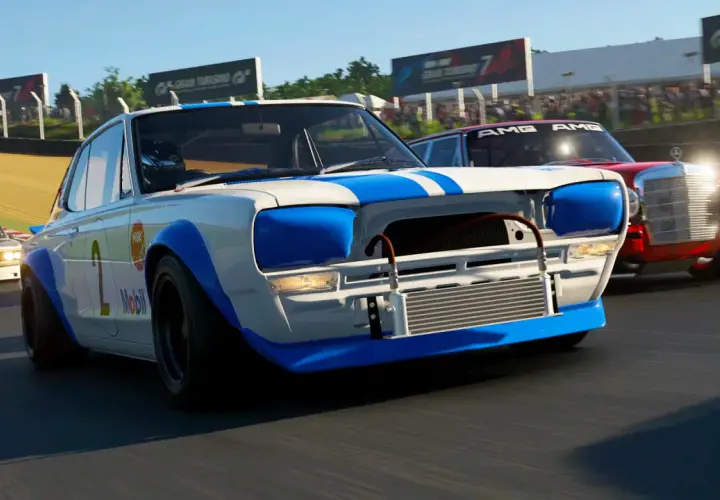 Auto da corsa bianche e blu con numero 2 in primo piano, in gara con altre auto, un aggiornamento di Gran Turismo 7.
