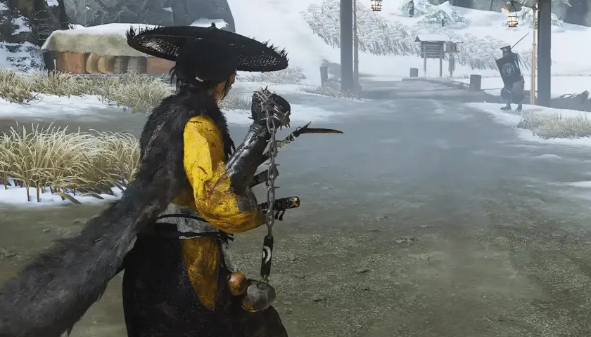 Un guerriero con un cappello conico e un mantello di pelliccia si prepara a combattere in un paesaggio innevato, forse in Ghost of Tsushima 2.