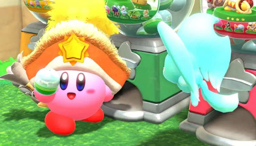 Kirby e la Terra Perduta recensione: Kirby con un cappello a stella dorata e un oggetto in mano, vicino a una macchina colorata.