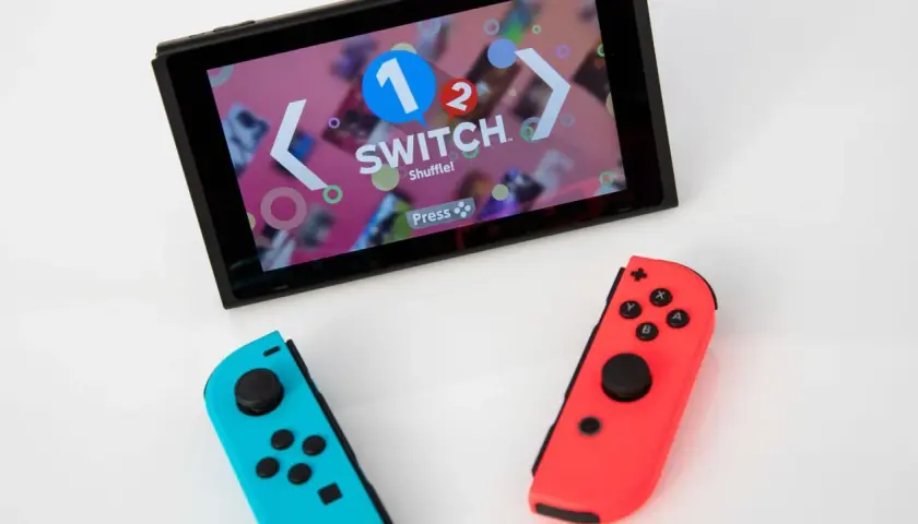 Nintendo Switch con Joy-Con blu e rossi, pronto per le vendite. Schermo mostra "1-2-Switch".