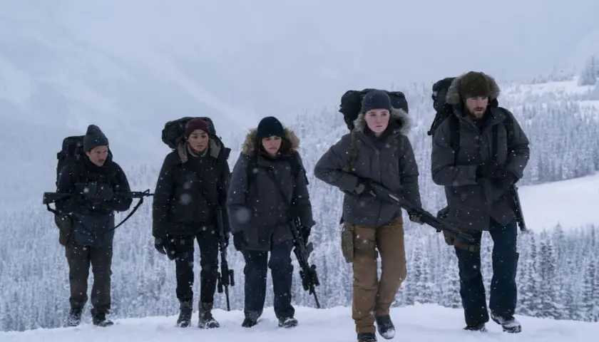 Un gruppo di sopravvissuti armati cammina nella neve, un'immagine che evoca la tensione di "the last of us 3".