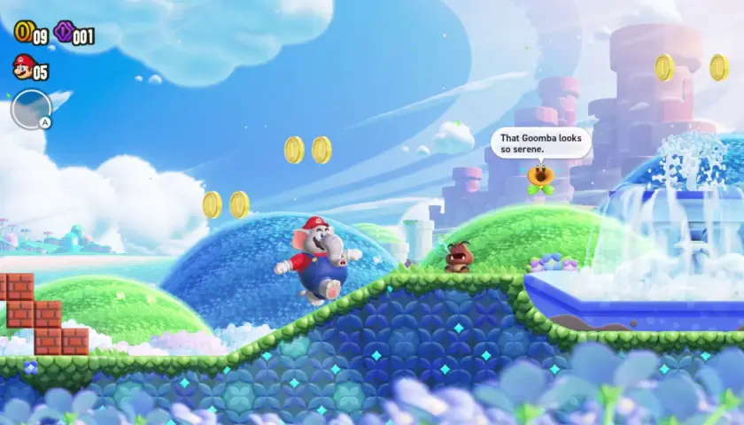Mario, trasformato in elefante, salta in un mondo colorato di Super Mario Bros. Wonder. Un Goomba osserva una fontana serena.