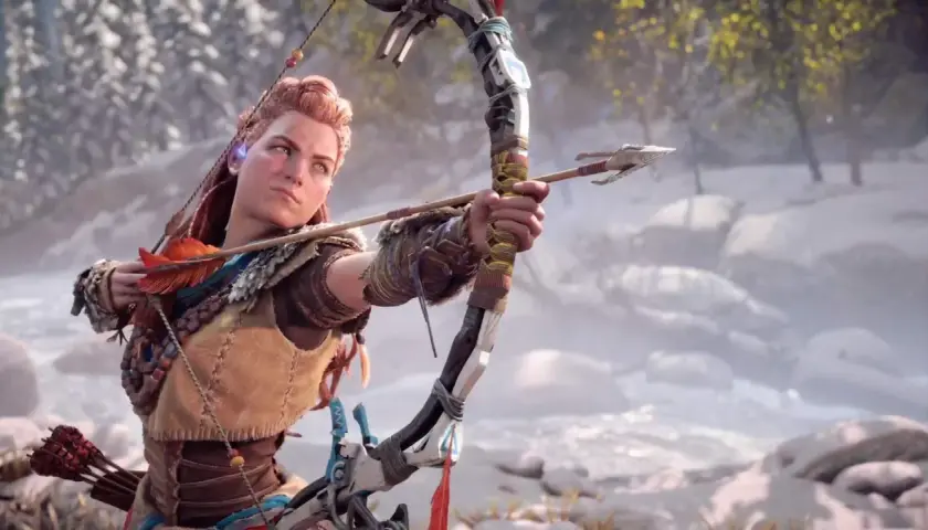 Aloy mira con determinazione, arco teso, pronta a scoccare una freccia. L'ambientazione innevata suggerisce nuove sfide in Horizon Forbidden West DLC.