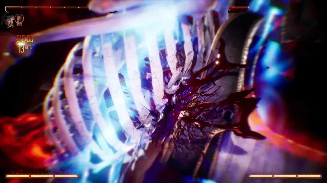 Un terrificante mortal kombat fatality: le costole si frantumano sotto un fascio di luce blu, rivelando un interno sanguinolento.