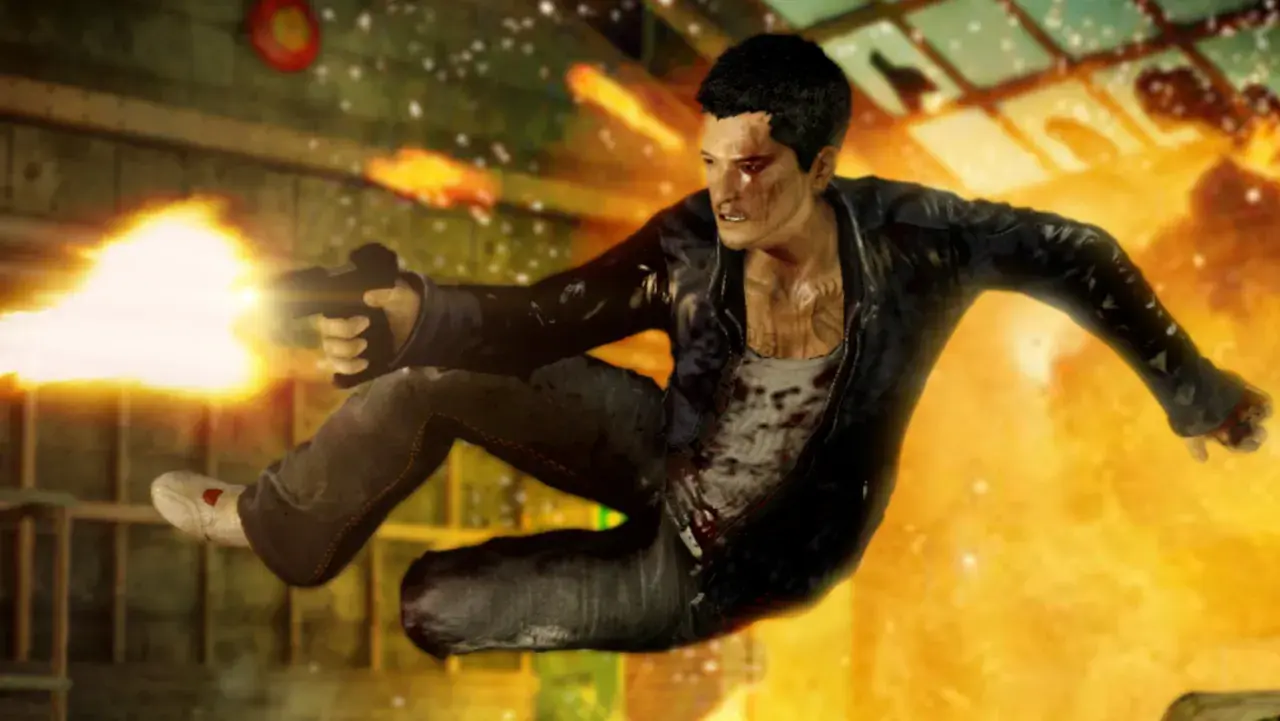 Un uomo salta in aria sparando con una pistola, circondato da fiamme e detriti. Un'intensa scena d'azione da Sleeping Dogs 2.