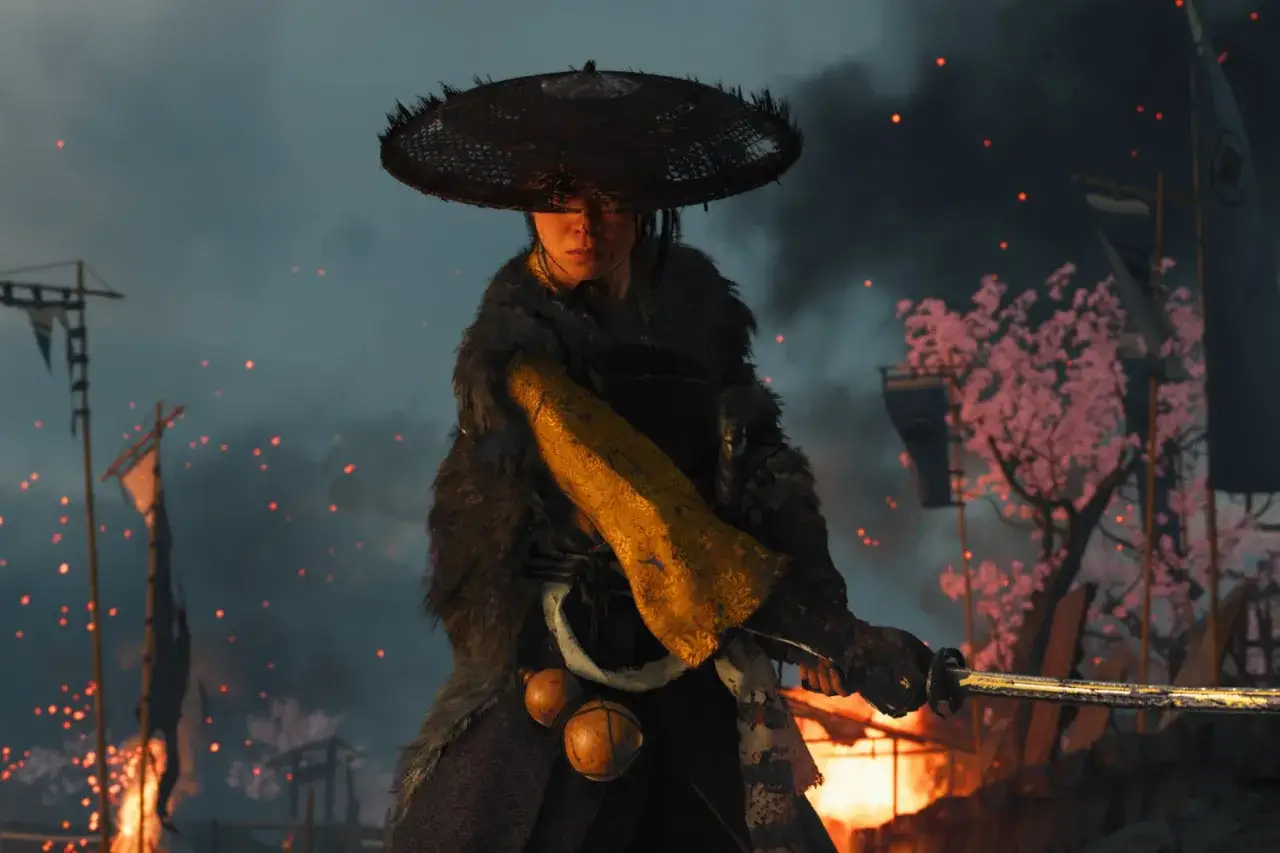 Guerriera con katana, sullo sfondo un campo di battaglia in fiamme e ciliegi in fiore. L'atmosfera evoca il Ghost of Tsushima 2.