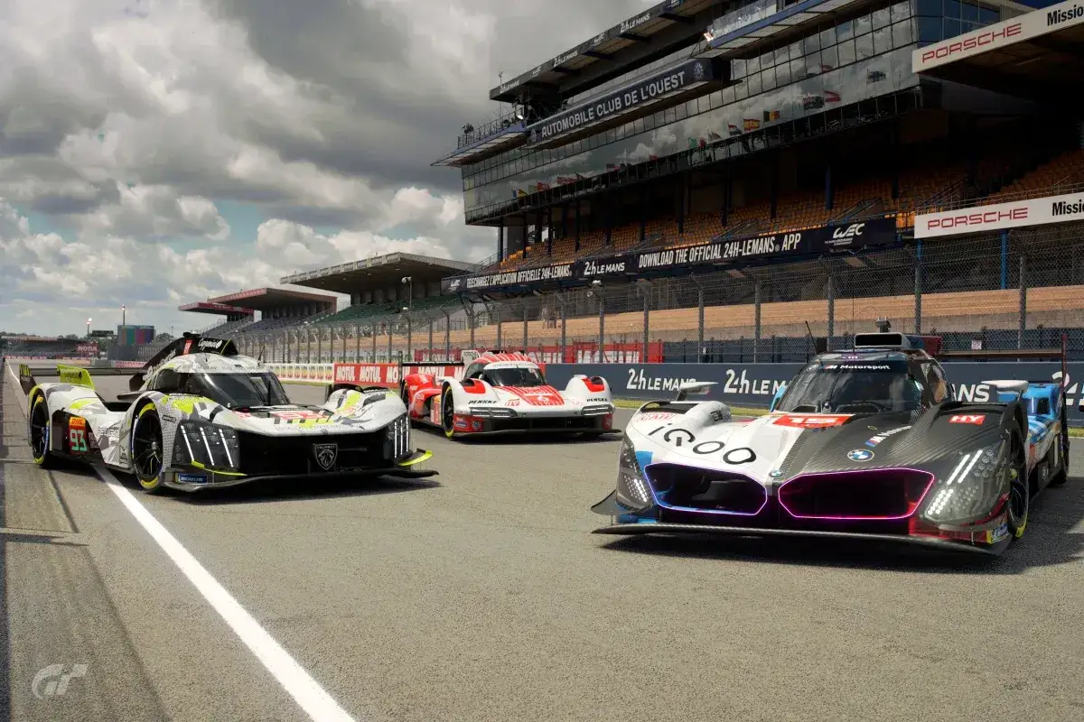 Tre prototipi da corsa su un circuito, pronti per un aggiornamento Gran Turismo 7. Le auto sono Peugeot, BMW e una rossa.