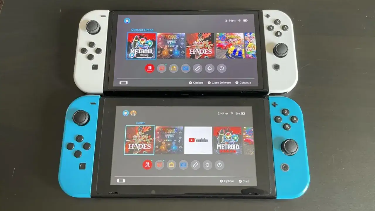 Due modelli Nintendo Switch, uno bianco e uno blu, mostrano le schermate dei giochi Metroid Dread e Hades.