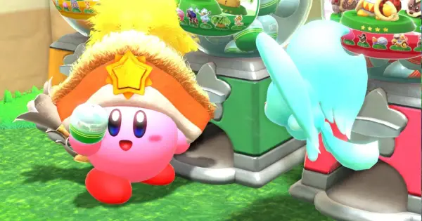 Kirby e la Terra Perduta recensione: Kirby con un cappello a stella dorata e un oggetto in mano, vicino a una macchina colorata.